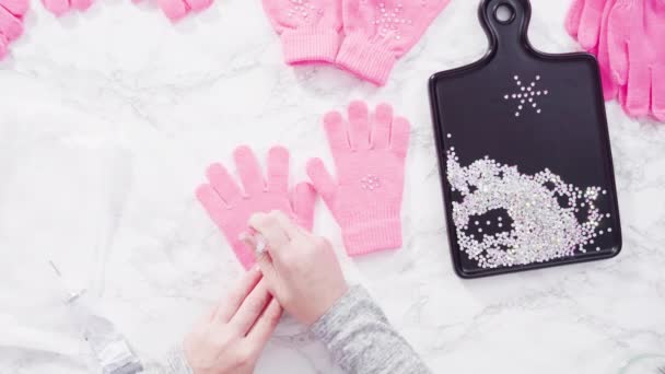 Flat lay. Rhinestone pink kids gloves with snowflake shapes. - Footage, Video