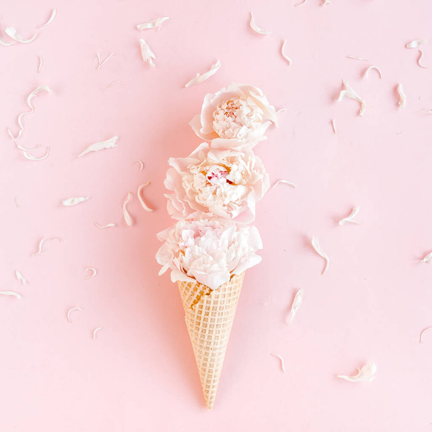 Waffle cone with peonies flower on pink background. Flat lay, top view floral background. - Valokuva, kuva
