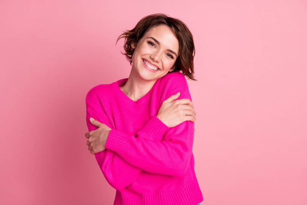 Photo of overjoyed lady good mood hands hug herself shoulders enjoy joyful soft cloth laundry warmth toothy smile wear casual bright sweater isolated pink pastel color background - Foto, afbeelding
