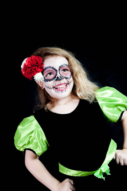 Une fille caucasienne habillée en sorcière à Halloween et peinte typiquement mexicaine le jour des morts - Photo, image