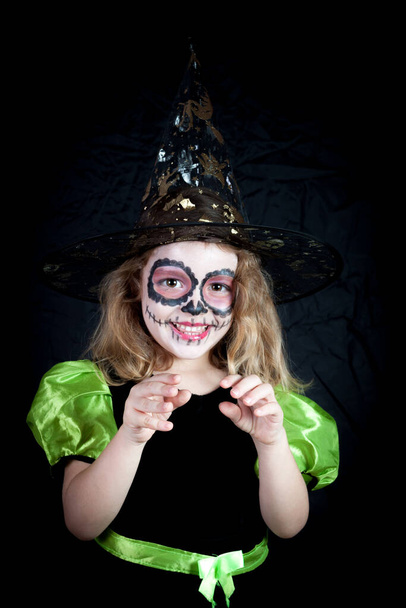 Una chica caucásica vestida de bruja en Halloween y pintada típicamente mexicana en el Día de los Muertos - Foto, imagen