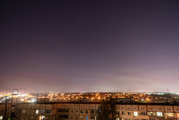 Éjszakai csillagos városkép sok csillagkal és csillagképpel. Kilátás a toronyháztetőről. - Fotó, kép