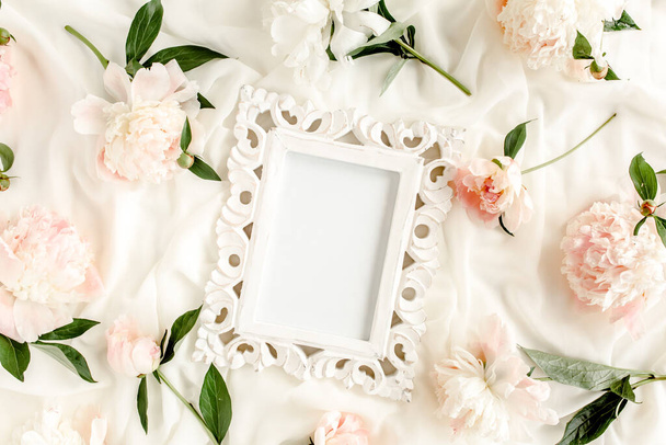 Carved, white frame decorated of beautiful and beige peonies. Flat lay, top view. Valentines background. Floral frame. Peony texture. - 写真・画像