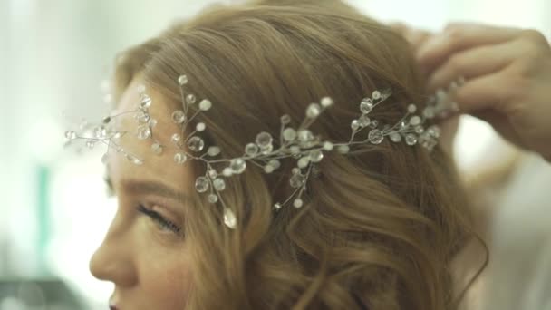 Increíble atractivo cabello rubio joven modelo preparándose para la celebración de la fiesta en maravillosa perl joyería tiara - Metraje, vídeo