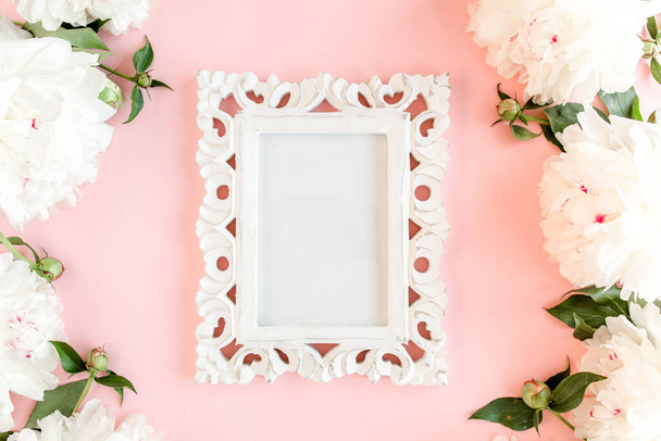 Carved, white frame decorated of white peony flowers on pink background. Peony texture. Flat lay, top view.  - Фото, зображення