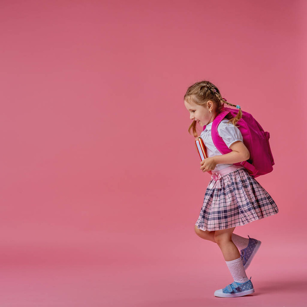Back to school! Cute hardworking kid in uniform Jogging on pink background. Child with backpack. little girl is ready for school. Dynamic images that go back to conceptual school. beginning holidays. - Foto, immagini