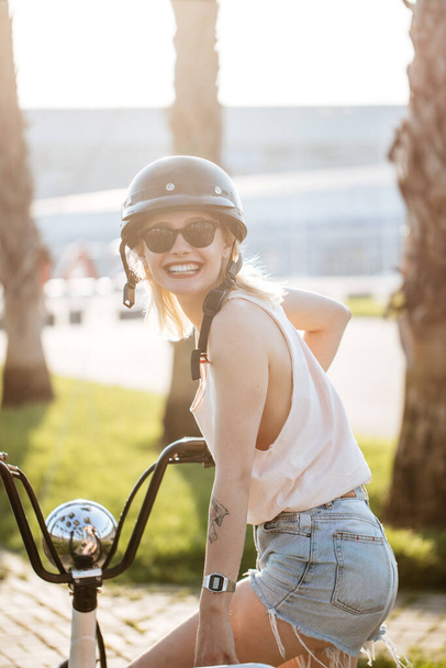Woman on a bike in the city on a sunny day - Fotografie, Obrázek