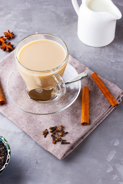 Masala chai tea. Traditional indian drink - masala tea with spices on gray background. Top view - 写真・画像