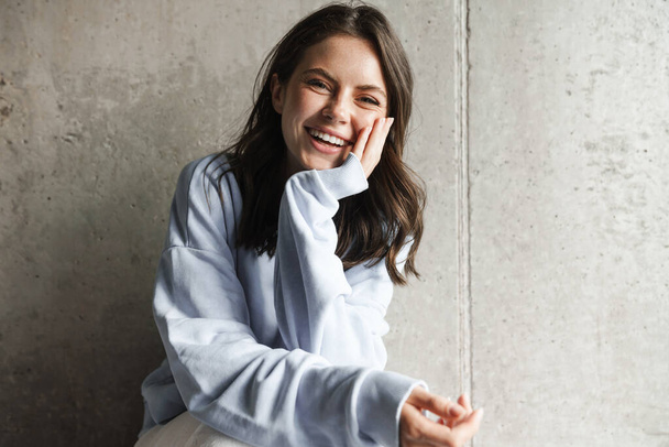 Image of charming joyful woman smiling and looking at camera while posing at home - Zdjęcie, obraz