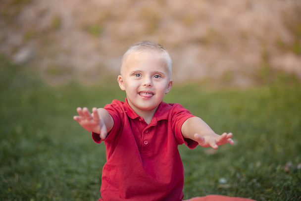Портрет маленького симпатичного мальчика с синдромом Дауна, заботящегося о больных людях, генетических заболеваниях, образе жизни. - Фото, изображение