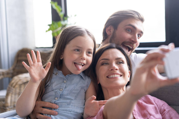 Cheerful family with children laughing taking selfie together on smartphone - Valokuva, kuva