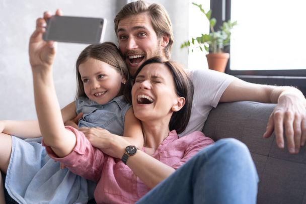 Cheerful family with children laughing taking selfie together on smartphone - Foto, Imagem