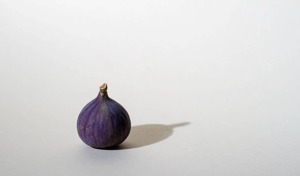 Figs of purple color on a light background with a shadow, bright light - Valokuva, kuva