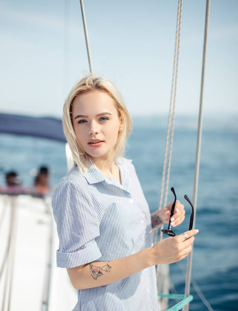 Young caucasian woman enjoying journey on yacht deck sailing the sea. - Фото, зображення