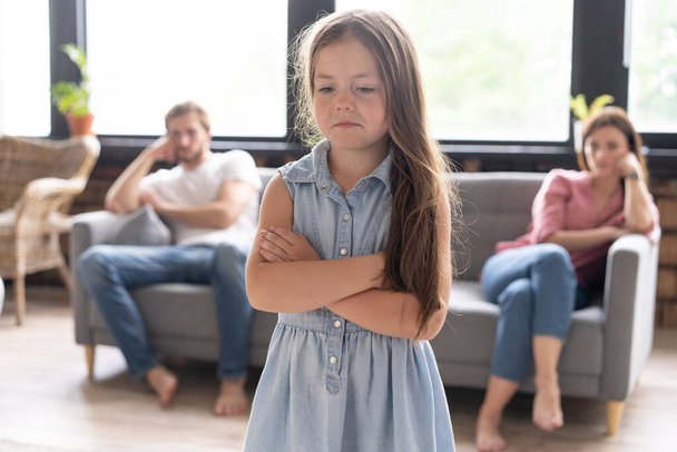 Closeup of a sad girl while parents quarreling in the home. - Zdjęcie, obraz