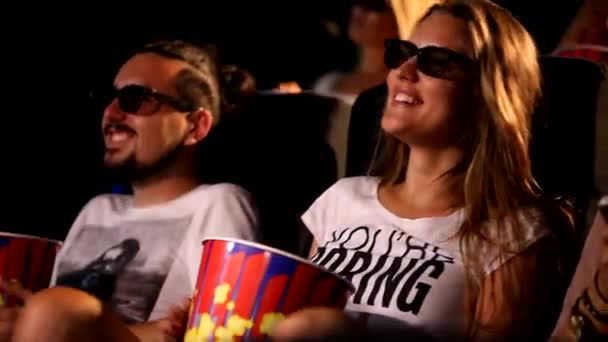 Egy csoport vonzó fiatal izgatott boldog nő férfi barátok eszik popcorn élvezi 3D 4d akciófilm mozi mozi - Felvétel, videó