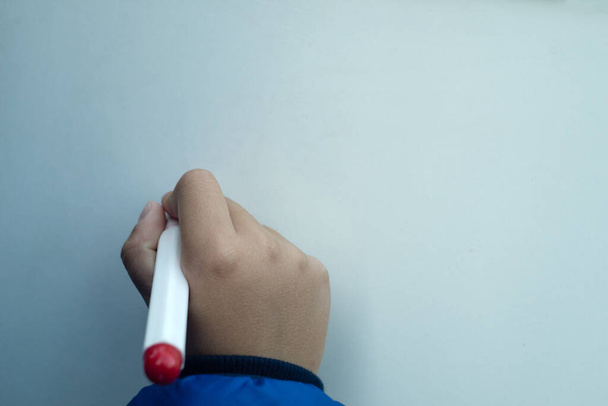 Child's hand with marker in hand, writing on a white Board, space for text - Fotoğraf, Görsel