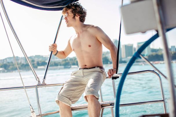 Man with frizzy hair relaxing happily on the vacation sailboat yacht - Zdjęcie, obraz