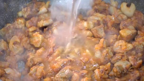 4K-Videoclip von Kochsoße, Dressing oder Soße mit Fleischstücken, Tomatenmark und Gemüse in Nahaufnahme. Gemüseeintopf mit Fleisch wird mit einem Spachtel vermischt. Der Prozess des Kochens von Abendessen - Filmmaterial, Video