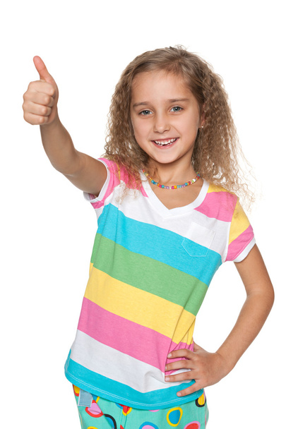 Hymyilevä tyttö pitää peukaloitaan pystyssä
 - Valokuva, kuva