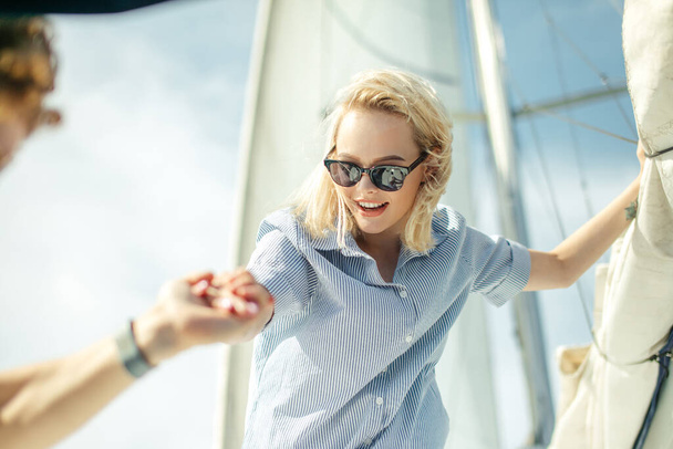 Young caucasian woman enjoying journey on yacht deck sailing the sea. - Foto, afbeelding