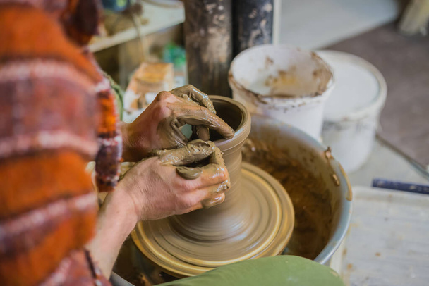Professionele mannelijke pottenbakker maken pot in aardewerk workshop - Foto, afbeelding