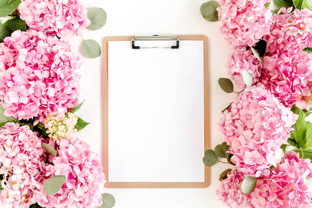 Carved, white frame decorated of pink hydrangea flowers on white background. Floral concept. Flat lay, top view.  - Φωτογραφία, εικόνα