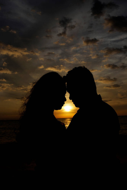 Pár muž a žena se drží za ruce na pozadí západu slunce. - Fotografie, Obrázek