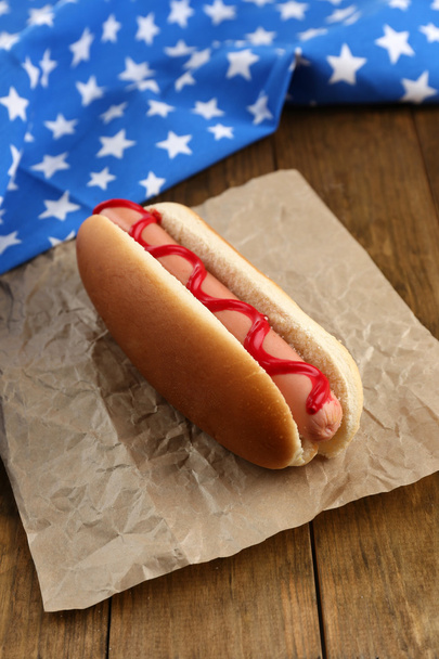 Tasty hot dog on wooden table - Valokuva, kuva