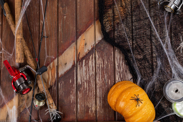 Vissen tacles op houten achtergrond in Halloween designe met spaders en web. Mockap voor reclame en uitgeverij. - Foto, afbeelding