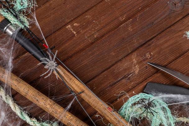 ハロウィーンの木製の背景に釣りのタックルは、クモやウェブで設計されています。広告や出版のためのMockap. - 写真・画像