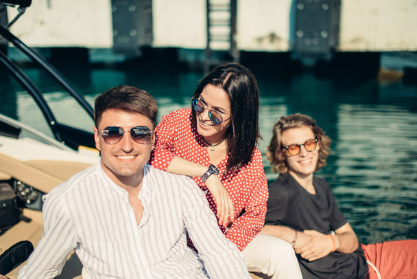 Friends resting on motor boat at marine pier, travelling on summer holiday. - Valokuva, kuva