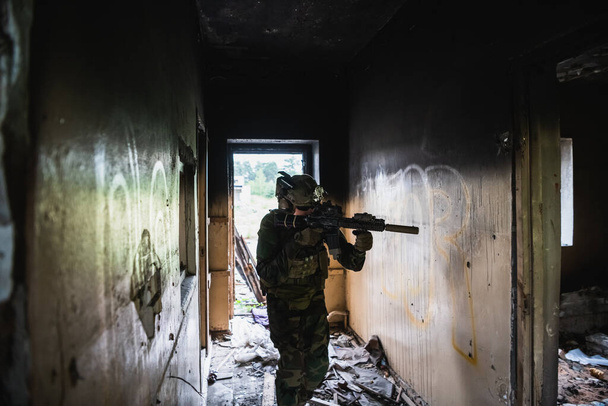 Katona a csatában. Városi harci kiképzés, katona belépett az elhagyatott épületbe. Terrorizmusellenes hadműveleti kiképzés. - Fotó, kép