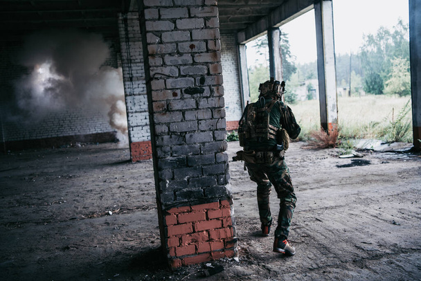 Soldaat in de strijd. Stedelijke gevechtstraining, soldaat gaat verlaten gebouw binnen. Anti-terroristische operatie training op slagveld. - Foto, afbeelding