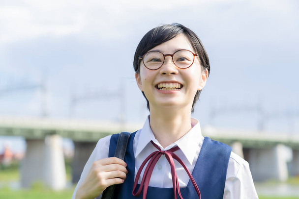 Azjatyckie licealistki w mundurach i uśmiechnięte w szkole - Zdjęcie, obraz