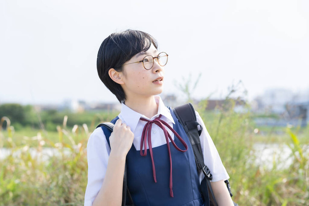Asiatico liceo ragazze indossare uniformi e sorridente a scuola - Foto, immagini
