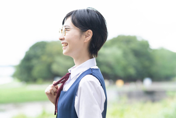 Asiático de la escuela secundaria niñas usando uniformes y sonriendo en la escuela - Foto, imagen