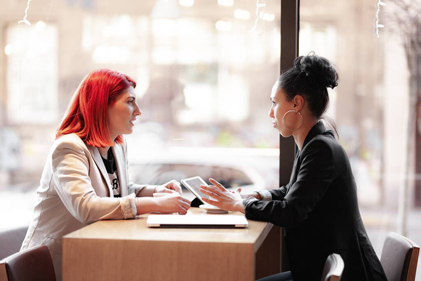 Two female business friends having a meeting at a cafe. - Fotó, kép