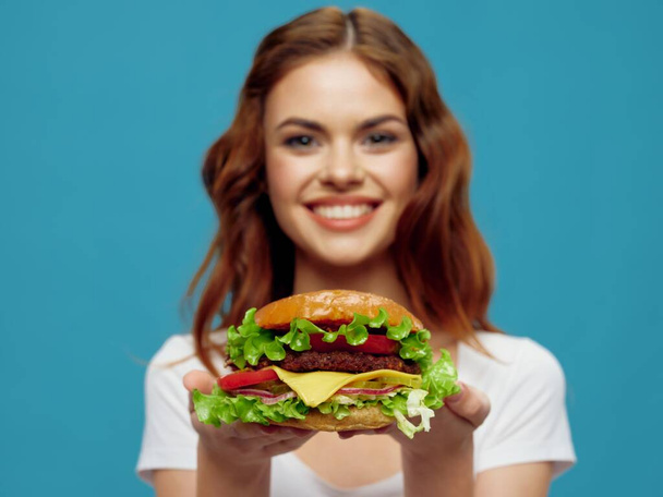 Frau hält Hamburger in Nahaufnahme Fast-Food-Diät-Essen Lächeln  - Foto, Bild