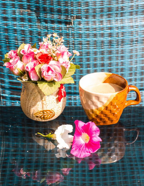 Natura morta, tazza di caffè bianco rosa fiori di plastica e petunia
 - Foto, immagini