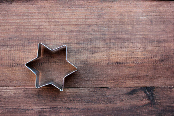 Cięcia w kształcie gwiazdy Bożego Narodzenia na drewnianym stole. Świąteczne tło. Widok z góry, przestrzeń kopiowania - Zdjęcie, obraz