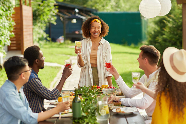 Portré fiatal afro-amerikai nő nevet vidáman, miközben élvezi a vacsorát a barátaival szabadtéri teraszon nyáron, másolja tér - Fotó, kép