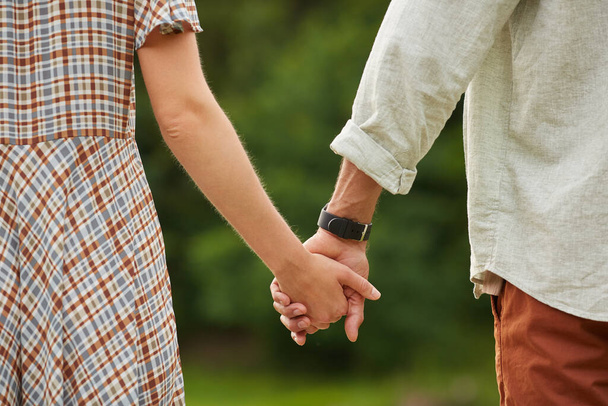 Zbliżenie romantycznej pary dorosłych trzymając się za ręce w wiejskiej scenerii, przestrzeń do kopiowania - Zdjęcie, obraz