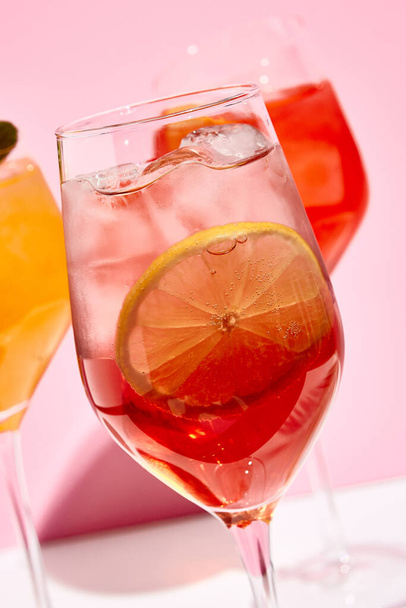 Raspberry spritz cocktail. Pink background. Cocktail with lemon slice and ice - Photo, image