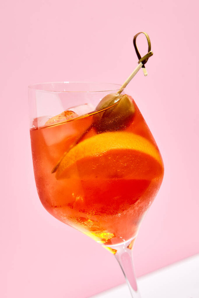 Aperol spritz on pink background. Pink and white background. Hard light and shadow - Photo, image