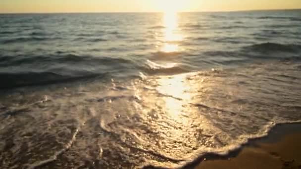 Νεαρή γυναίκα έρχεται στο νερό το ηλιοβασίλεμα στην αμμώδη παραλία, διακοπές στο νησί - Πλάνα, βίντεο