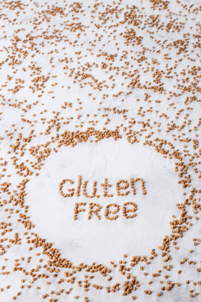 gluten-free products-buckwheat is scattered on the table. Gluten-free buckwheat label. - Photo, Image