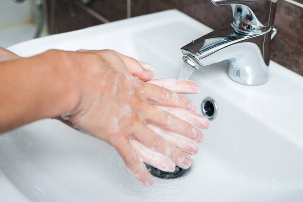 Hygiene concept. Washing hands with soap under the faucet with water - Foto, immagini