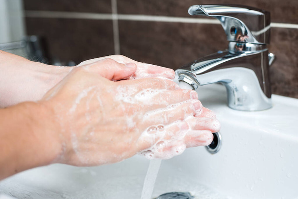 Hygiene concept. Washing hands with soap under the faucet with water - 写真・画像