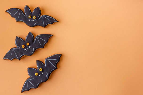 Halloween pattern for postcard. Cheerful black bats are isolated on an orange background. Congratulations on the holiday. Children's food on the festive table. Hand made treats. Copy space. mock up - Photo, image